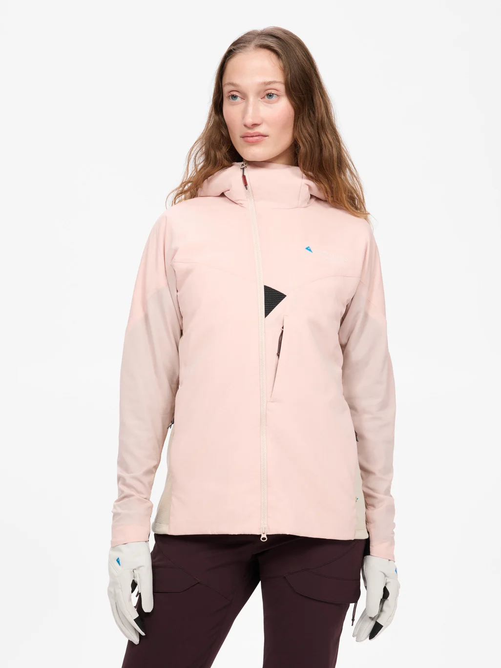 Woman wearing a pale pink Klättermusen hooded jacket and light gray gloves, front view.