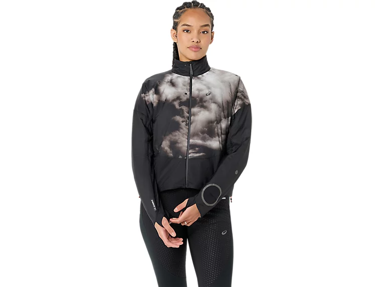 Woman wearing a black cropped jacket with a gray cloud print and black leggings, front view.