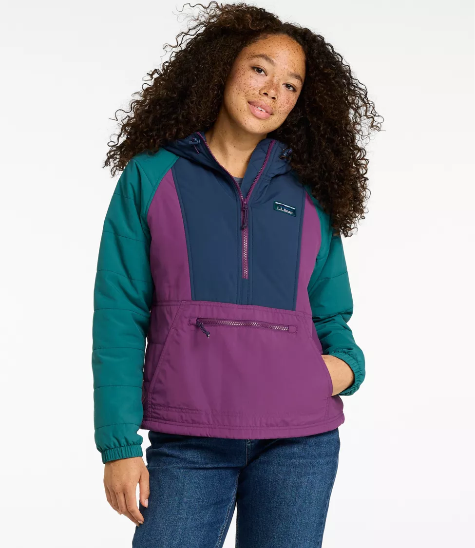 Woman wearing a navy, purple, and teal L.L.Bean anorak, smiling with a hand in the pocket.