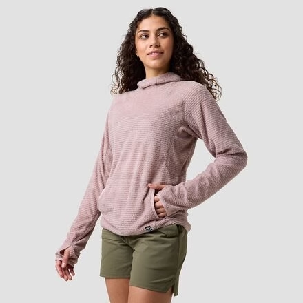 Woman wearing a mauve fleece pullover and olive shorts, one hand in pocket.