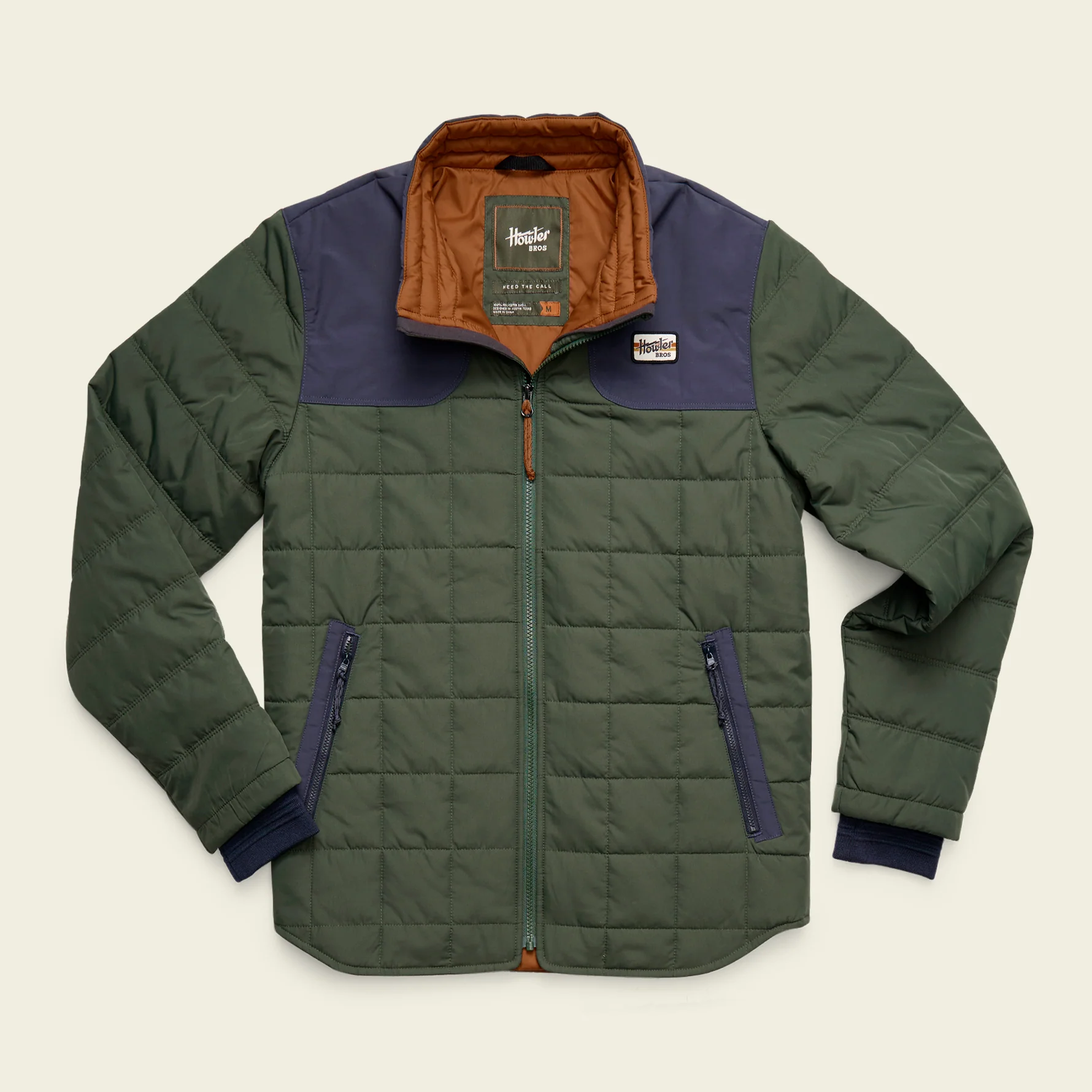 Green quilted shirt jacket with a navy shoulder yoke and rust-colored collar, flat lay product shot.