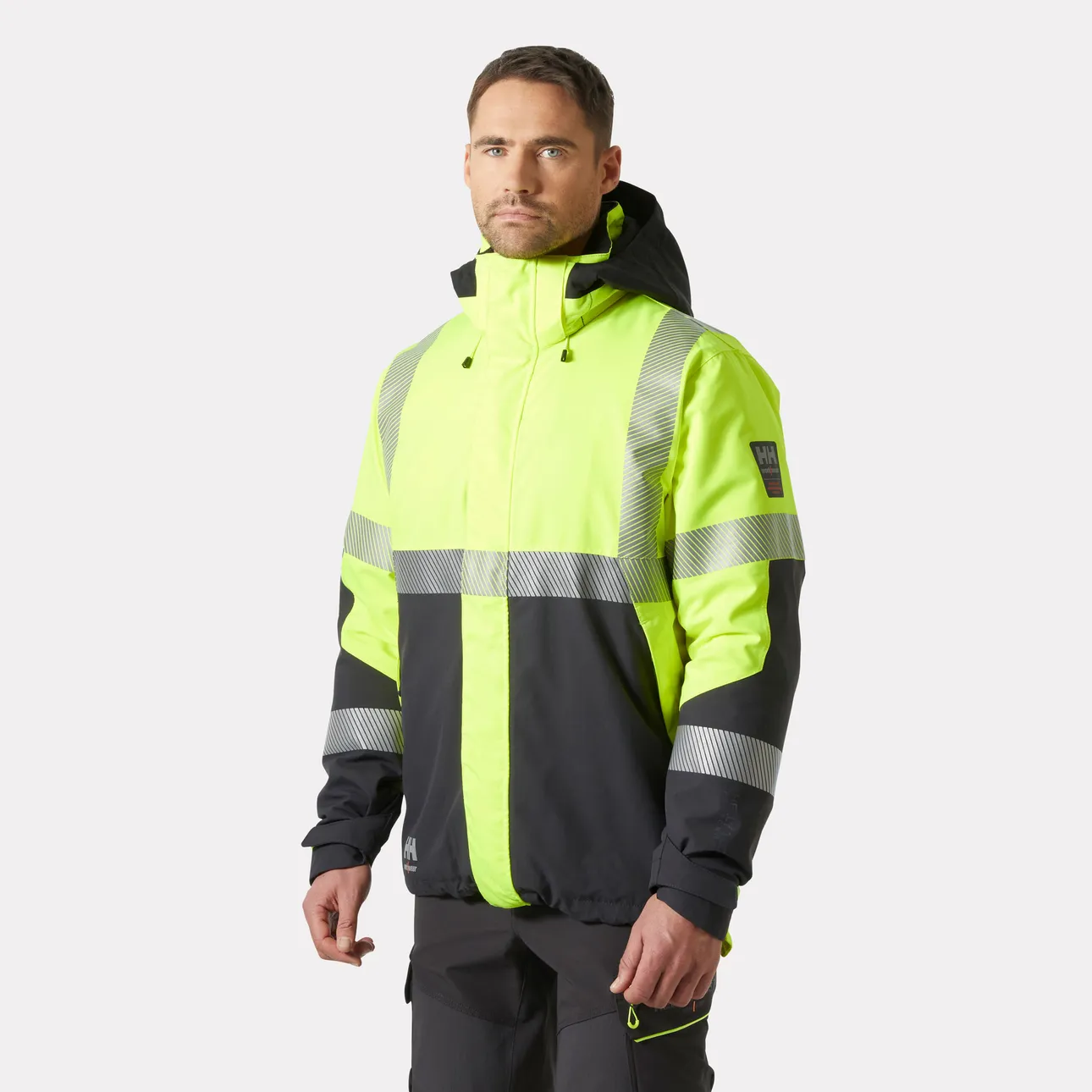 Man wearing a yellow and black Helly Hansen Workwear high-vis jacket, front view.