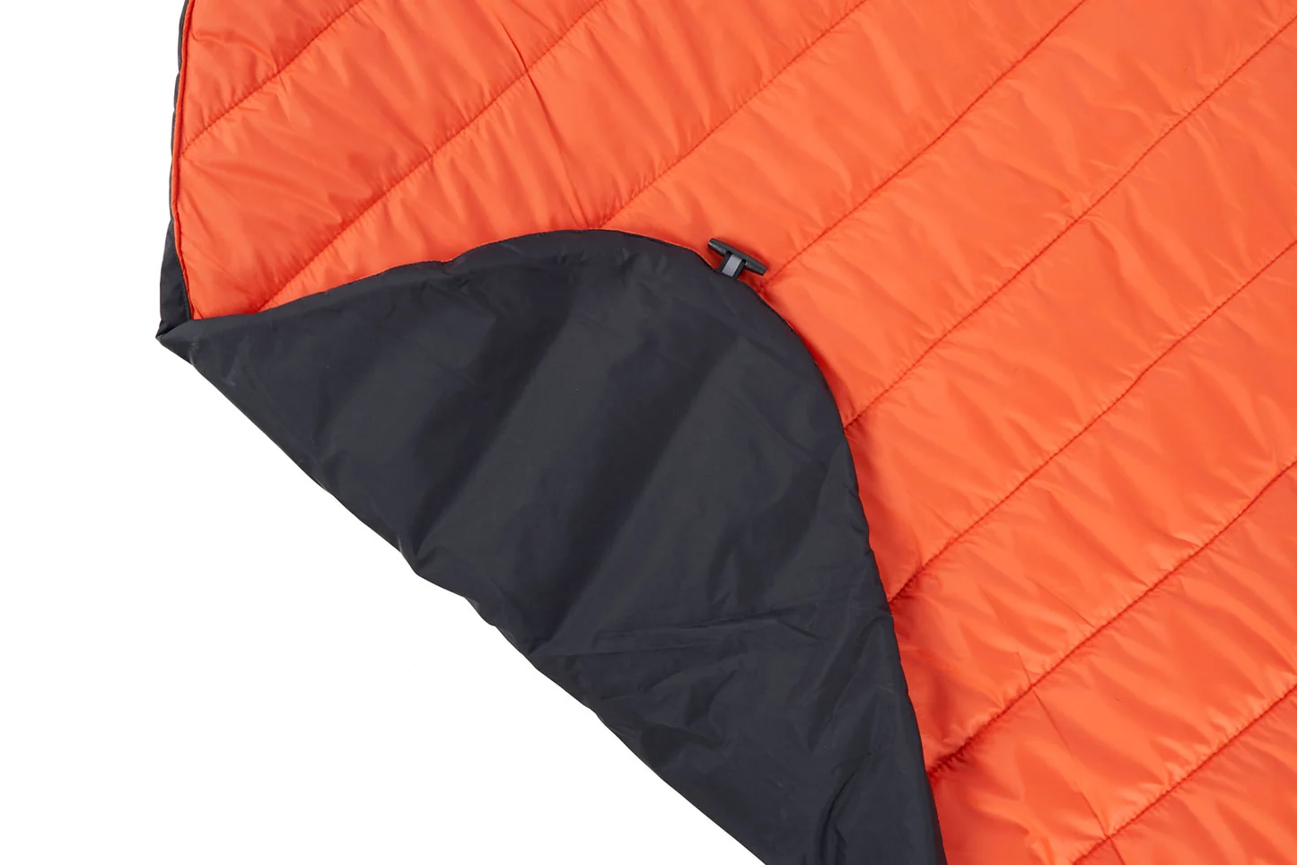 Orange quilted dog blanket with a folded corner showing its black lining.