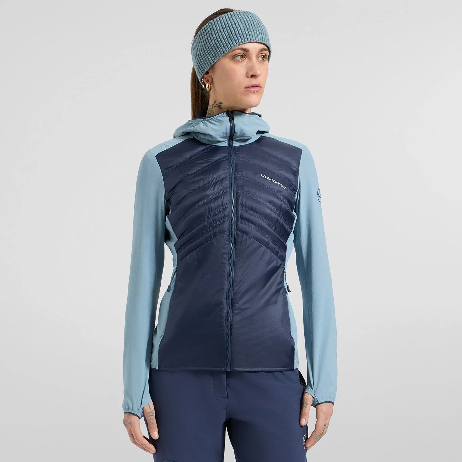 Woman wearing a navy and light blue La Sportiva hooded jacket and matching headband.
