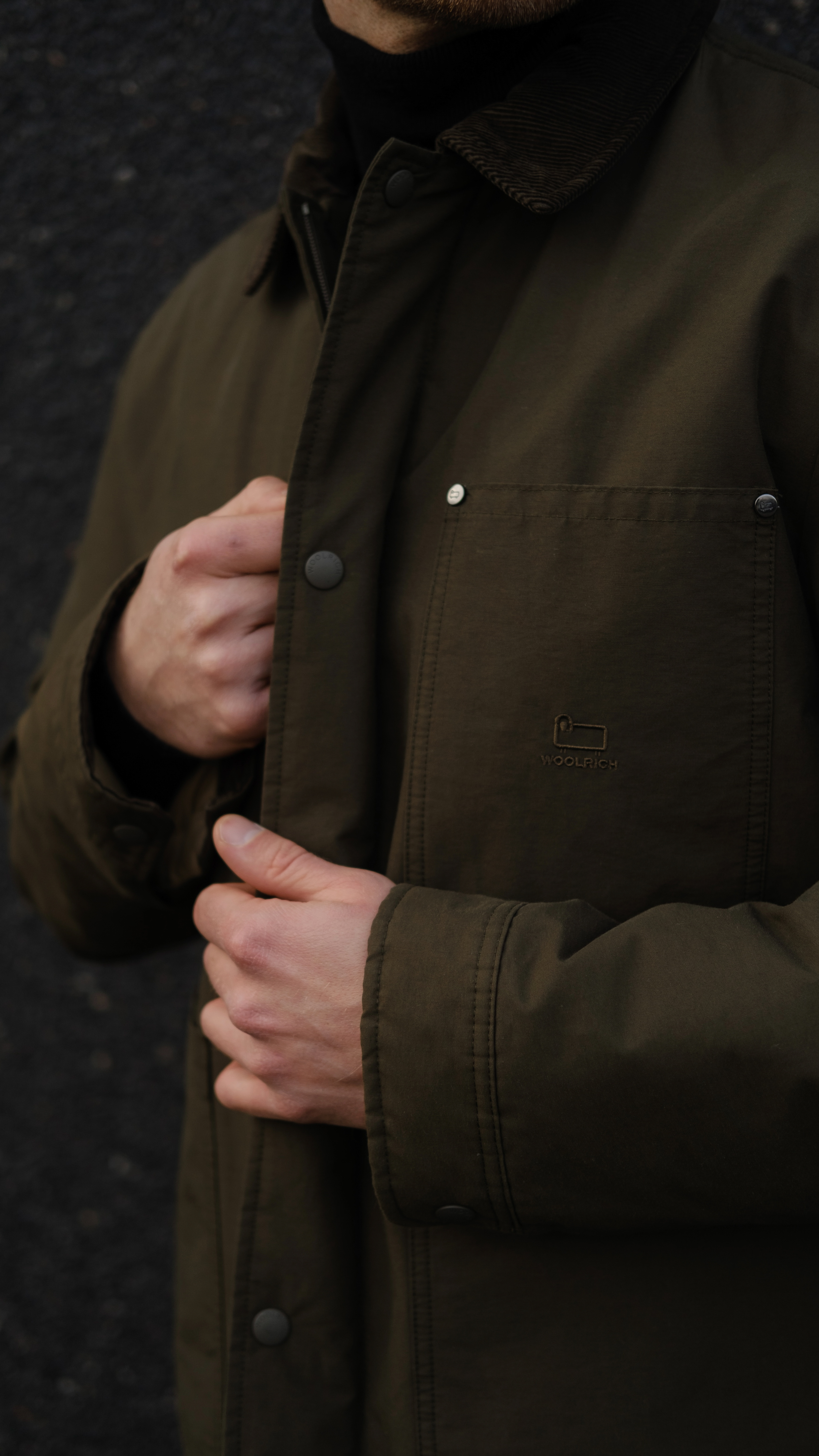 Man fastening jacket with PrimaLoft insulation designed for everyday durability and repeated wear